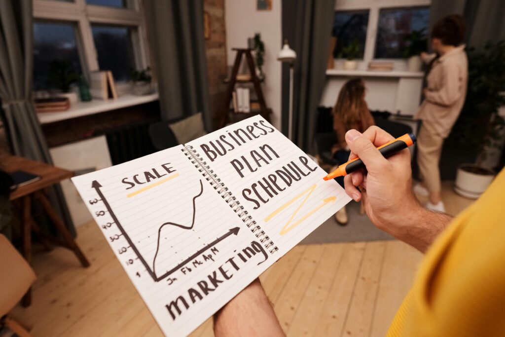 pexels-photo-6476797-6476797 Person holding a notebook with planning details and graph for business strategy indoors.